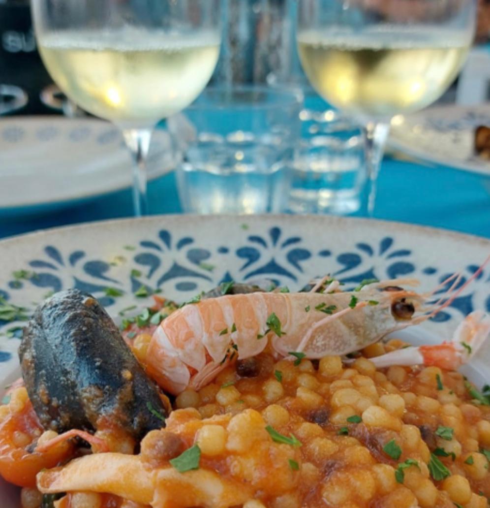 Fregola dish with wine in background